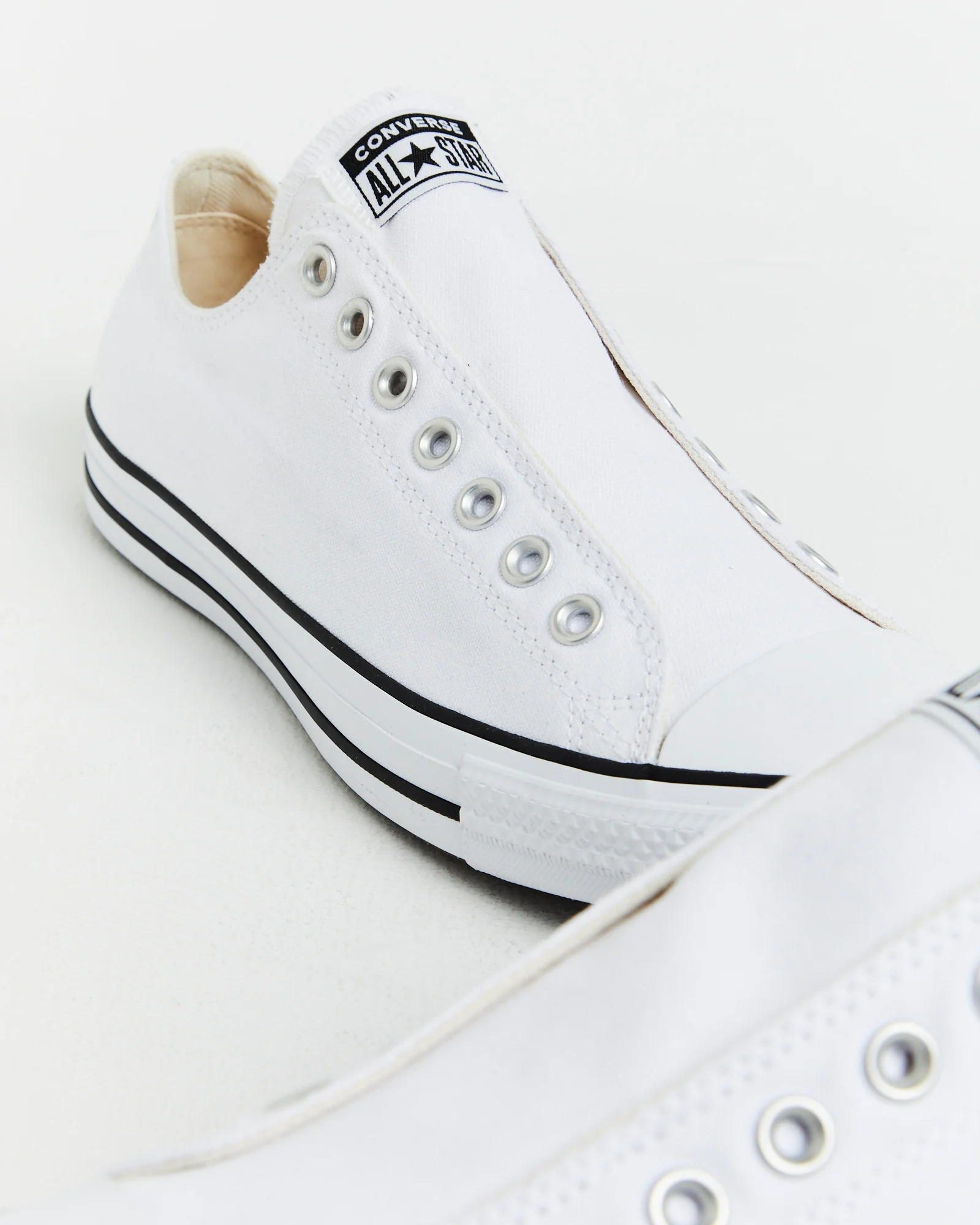 Chuck Taylor All Star Slip On Sneakers In White/Black - Image 4